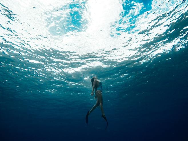 一个女人在游泳的鳍向水面游泳