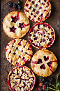 Six blackberry tarts with various designs