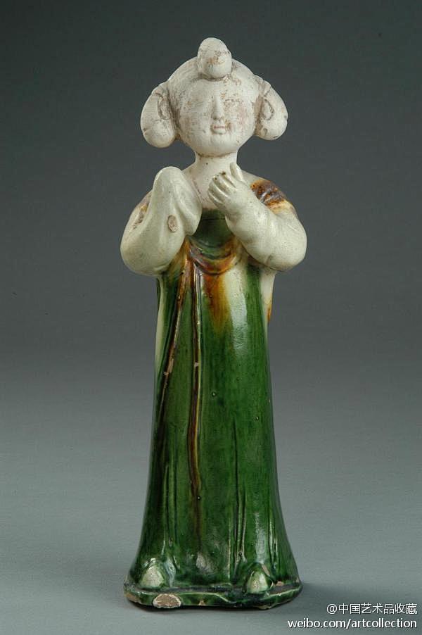 此女俑头梳宝髻垂练髻,身着窄袖曳地长裙,肩披