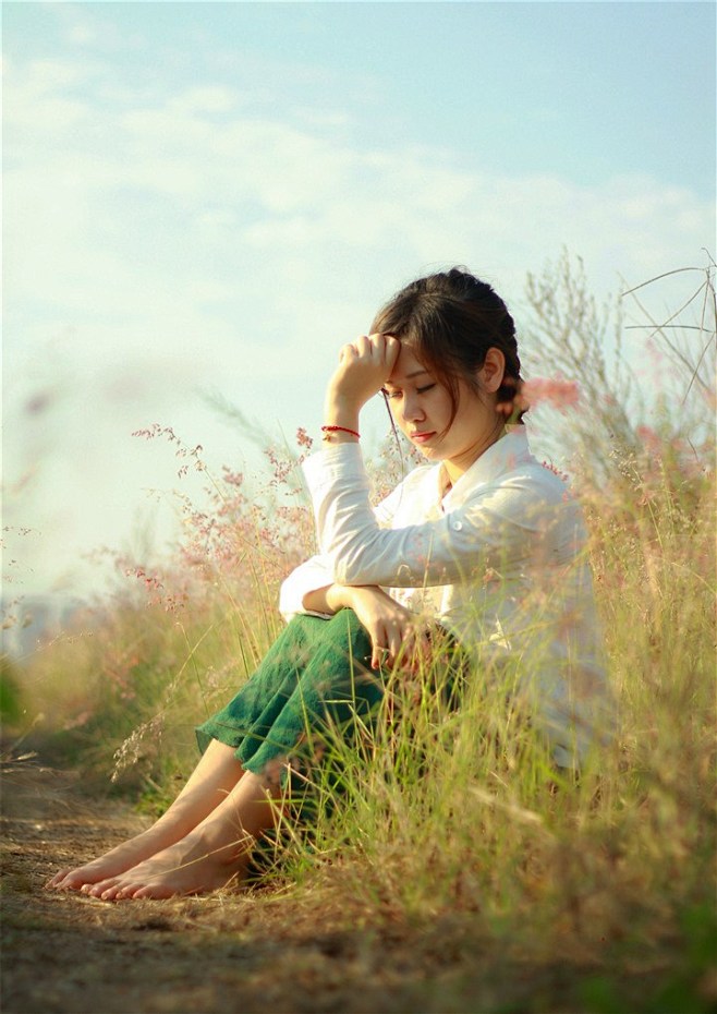 草丛中赤脚的沉思少女