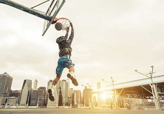 篮球街头球员做后扣篮纽约和曼哈顿大厦在背景中