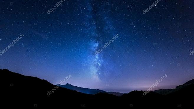 在山後面移動恆星和銀河系的夜空全景圖