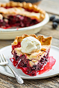 A slice of blackberry pie with a scoop of ice cream